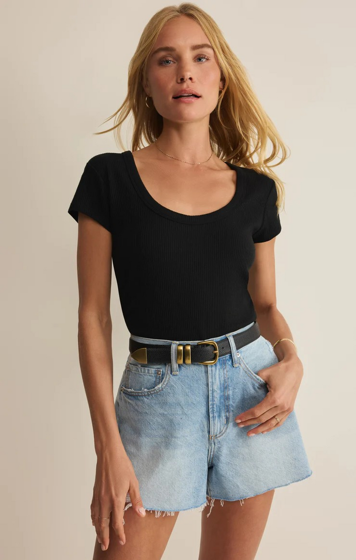 Woman wearing a black top and denim shorts on a beige background zs upply