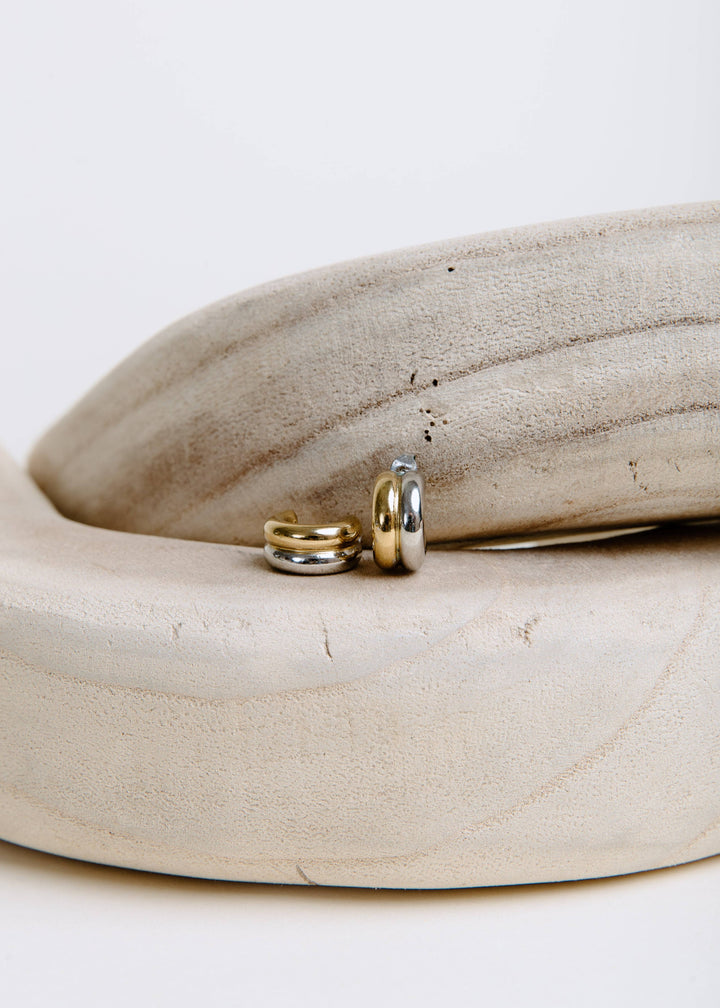 Vincent Intermix Holly hoops with gold-tone and silver-tone bands displayed on a cream ceramic dish