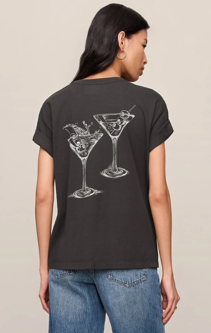 Person wearing a black t-shirt with martini glass designs on the back, standing against a beige background.
Z supply tee