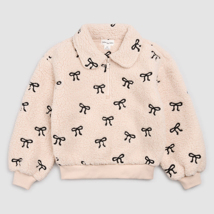 Miles the Label beige sherpa half-zip pullover with black embroidered bows and rounded collar