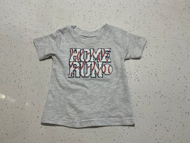 Gray t-shirt with 'HOME RUN' text on a speckled gray surface