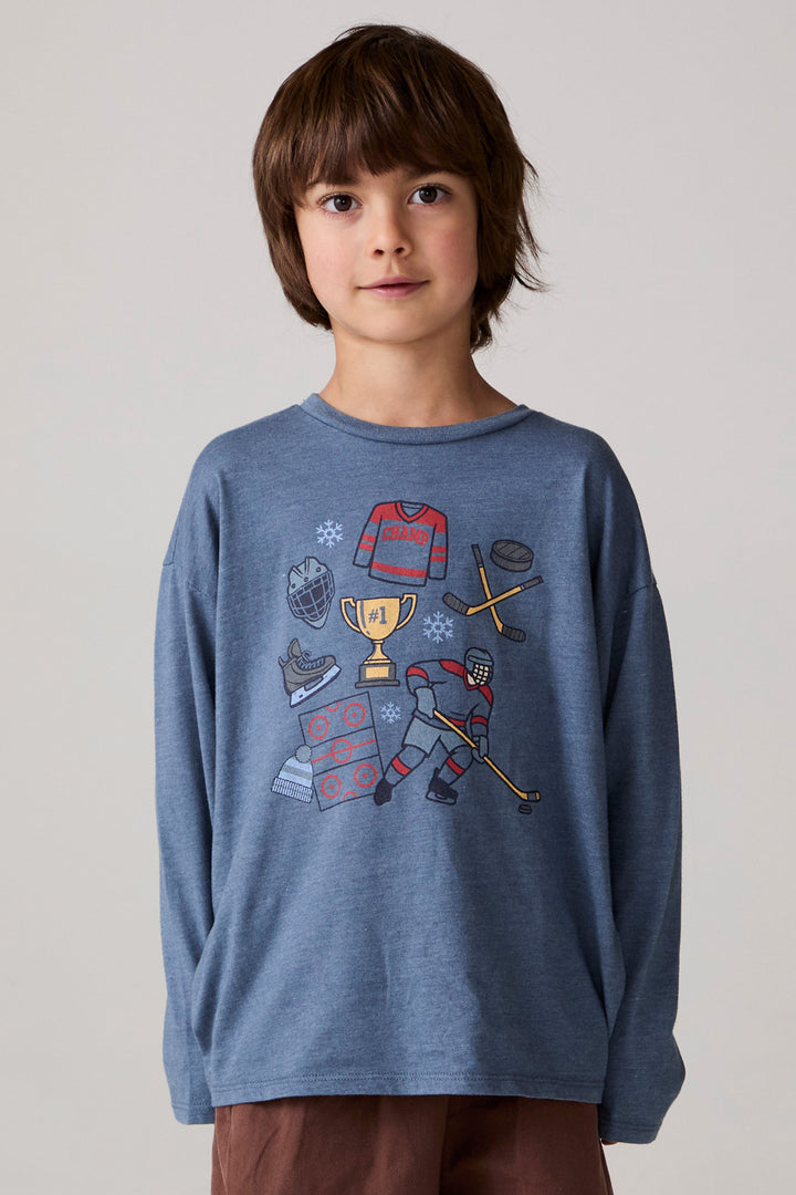 Model wearing Chaser's Champions Boys Long Sleeve Tee in blueberry jam with distinctive graphic and design details, front view; top only, coordinating bottoms sold separately