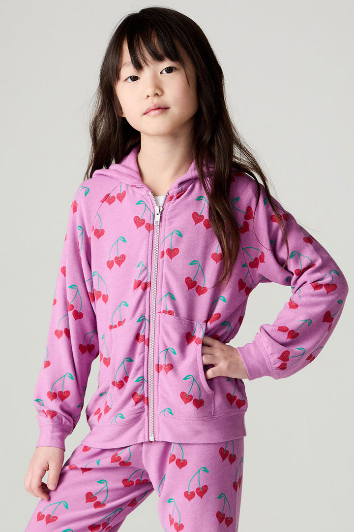 Front view of a girl wearing the Chaser Allover Sweethearts Girls Hoodie on a neutral background with matching pink pants; top only, coordinating bottoms sold separately