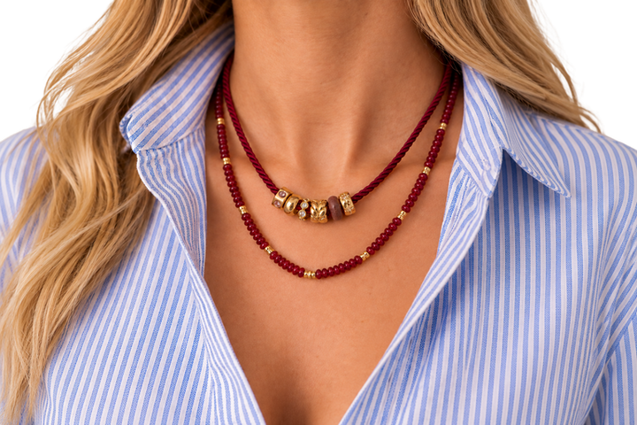 Model wearing the JLA Risa Ruby beaded necklace as the lower necklace, layered with a separate cord necklace