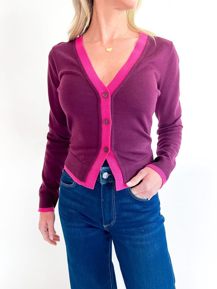 Steve Madden Arwen cardigan in Deep Fig with bright pink contrast trim, V-neckline and button front; jeans sold separately.